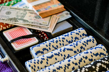 Cards and playing chips for playing poker. Banknotes with Euros and Dollars lie on dice and cards.の写真素材