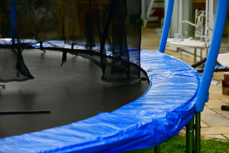 Disassembled trampoline in the yard after purchase. Assembly and installation in a private yard on a green lawn.の写真素材