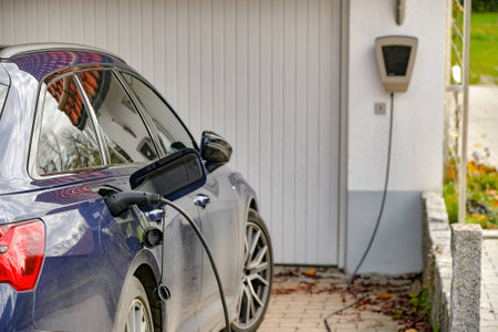 An electric car is charged from a gas station in a private house.の写真素材