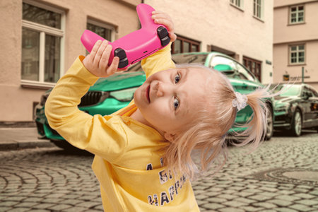 A little girl holds a game joystick in her hands