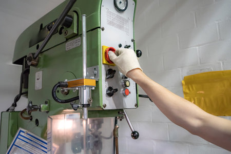 The worker operator of a mechanically controlled drilling machine performs work.