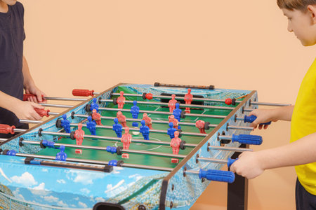 Two excited boys play table football.の写真素材