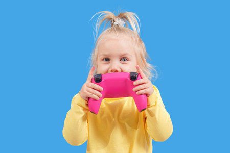 A little girl with a joystick in her hands from a game console.の写真素材