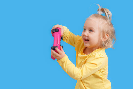 A little girl with a joystick in her hands from a game console.の写真素材