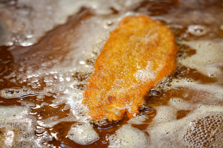 Fried schnitzel on the stove in the kitchen of a restaurant before serving the dish.の写真素材