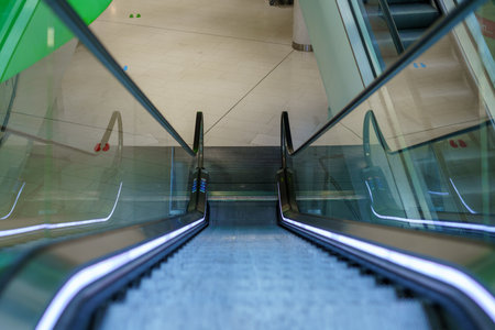 Empty escalator in a closed shopping center without people.