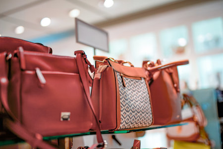 Red leather women's fashion bags from the new collection on sale in a shopping center.の写真素材