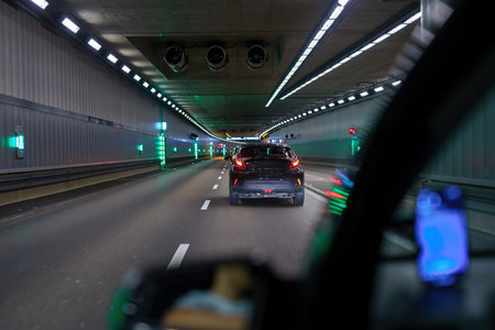 City road tunnel with cars on the road and artificial lighting.の写真素材