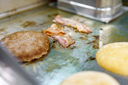 Fried bacon and cutlets for making a burger with cheese and vegetables.の写真素材