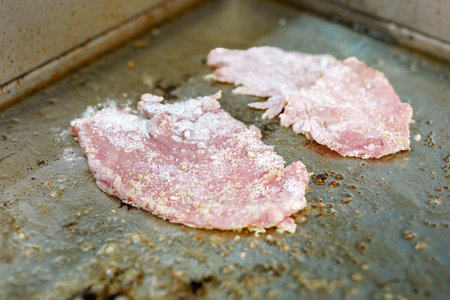 Frying a pork chop on the stove in a restaurant kitchen.の写真素材