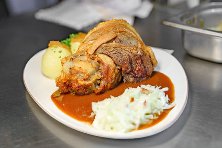 A dish of pork knuckle with potatoes and sauerkraut served in a restaurant.の写真素材