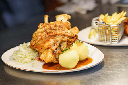 A dish of pork knuckle with potatoes served in a restaurant.の写真素材
