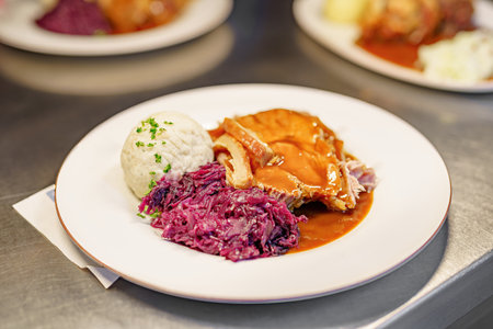 A dish of baked boiled pork and red cabbage in a restaurant.の写真素材