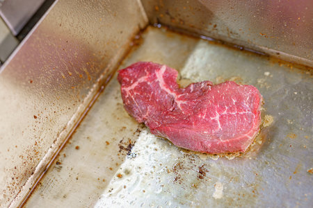 Fresh beef steak on the stove being prepared for a restaurant dish.の写真素材