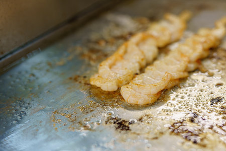 Cooking and frying shrimp on a stick in a restaurant kitchen.の写真素材