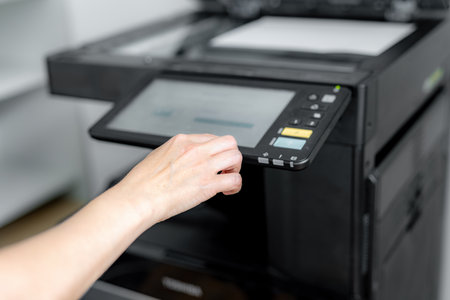 A girl sets up a photocopier to print and copy a document.の写真素材