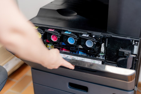 A girl checks the paint in a color laser printer.