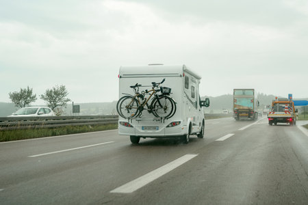 A motorhome on the motorway transports bicycles in the back of the car.