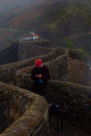 Girl chat with cellphone in stone bridge with dog