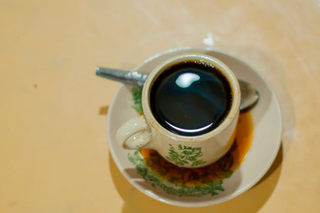 a cup of hot coffee on wood table with light bokeh backgroundの写真素材