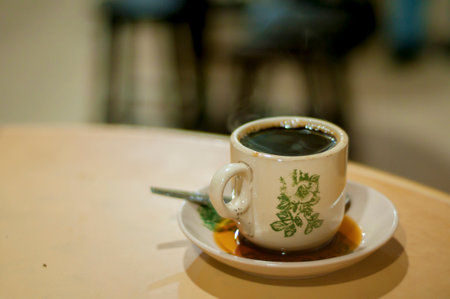 a cup of hot coffee on wood table with light bokeh backgroundの写真素材