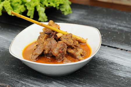 minced beef curry in a white bowl on a black wooden tableの写真素材