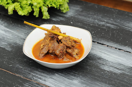 minced beef curry in a white bowl on a black wooden tableの写真素材