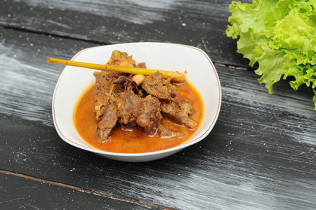 minced beef curry in a white bowl on a black wooden tableの写真素材