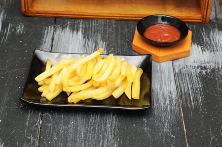 French fries on a black plateの写真素材
