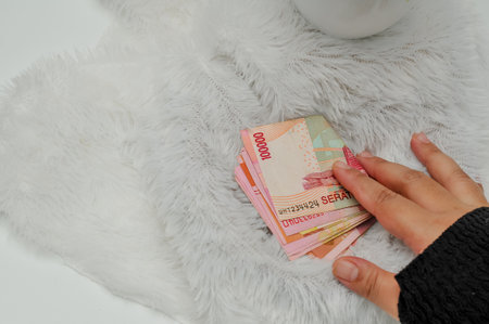 a hand hold indonesian currency on white carpetの写真素材