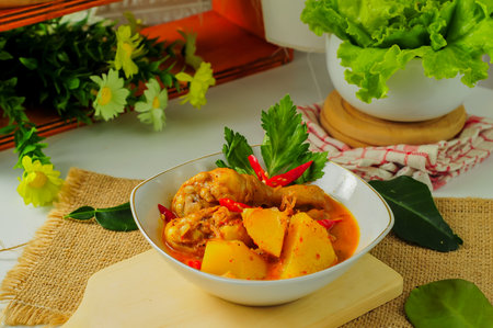 chicken curry with potatoes slices in white bowlの写真素材