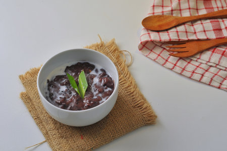 Black Glutinous Rice Porridge or Bubur Pulut Hitam in Malay with coconut milk on white backgroundの写真素材