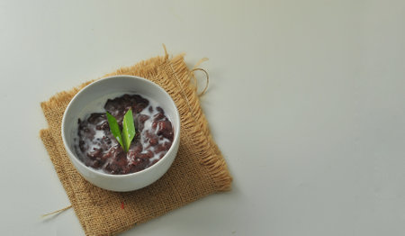 Black Glutinous Rice Porridge or Bubur Pulut Hitam in Malay with coconut milk on white backgroundの写真素材