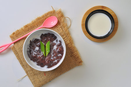 Black Glutinous Rice Porridge or Bubur Pulut Hitam in Malay with coconut milk on white backgroundの写真素材