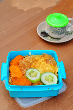 Breakfast with omelet and vegetables in blue lunch box.