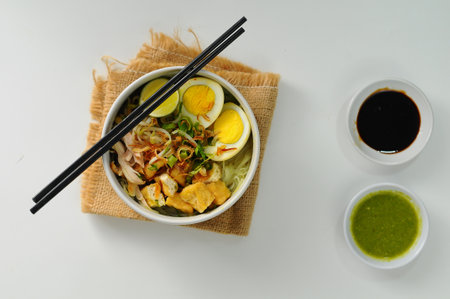 Bowl of Asian noodle soup with chicken, egg and vegetables