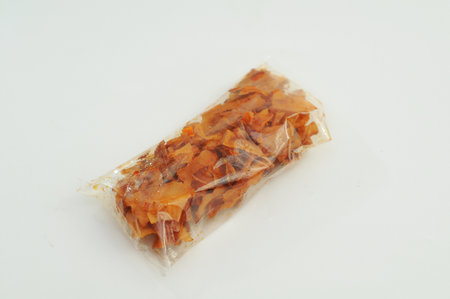 spicy sweet potato crackers in plastic, white background