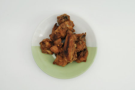 Fried chicken wings on green plate, isolated on white background.の写真素材