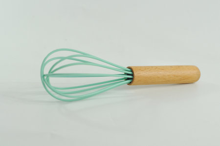 Metal whisk for whipping eggs on a white background. Closeup.
