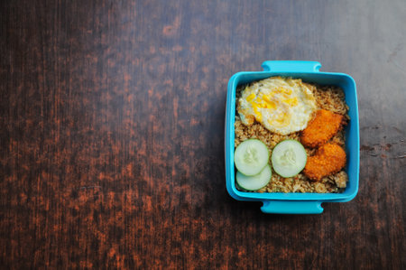 Lunch box containing fried rice, nuggets and eggsの写真素材