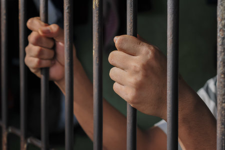 Man's hand is holding a metal cage. Close-up.の写真素材