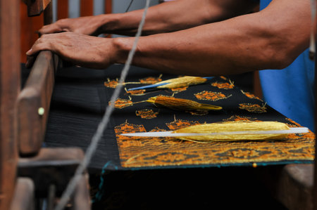 Detail of a hand weaving traditional silk thread on a loomの写真素材