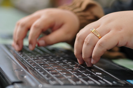 Close up of a woman's hand typing on a laptop keyboard.の写真素材
