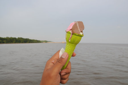 Ice cream in a green waffle cup on the background of the sea.の写真素材