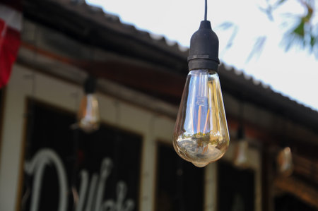 Vintage light bulb hanging on the wall of a cafe in Thailandの写真素材
