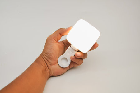 Hand holding a flashlight on a white backgroundの写真素材