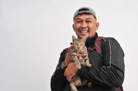 Handsome asian man carrying a cat on white background.