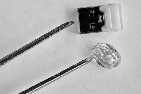 Tweezers and a stone with a flash drive