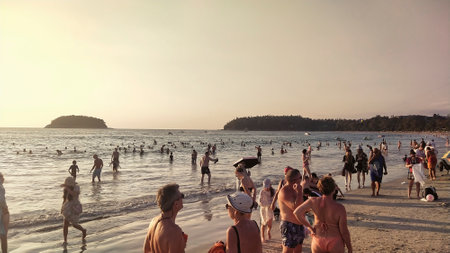 Crowds of people stroll along the sandy sea beach.の写真素材