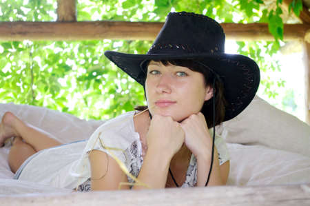 beautiful girl in the hat lying in the open airの写真素材